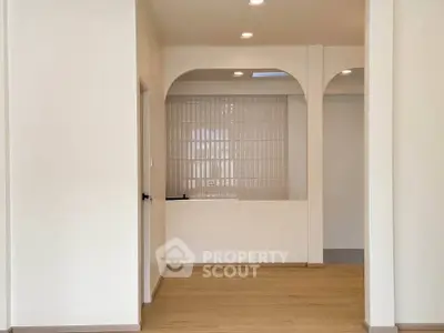 Spacious modern interior with elegant arches and wooden flooring, perfect for stylish living.