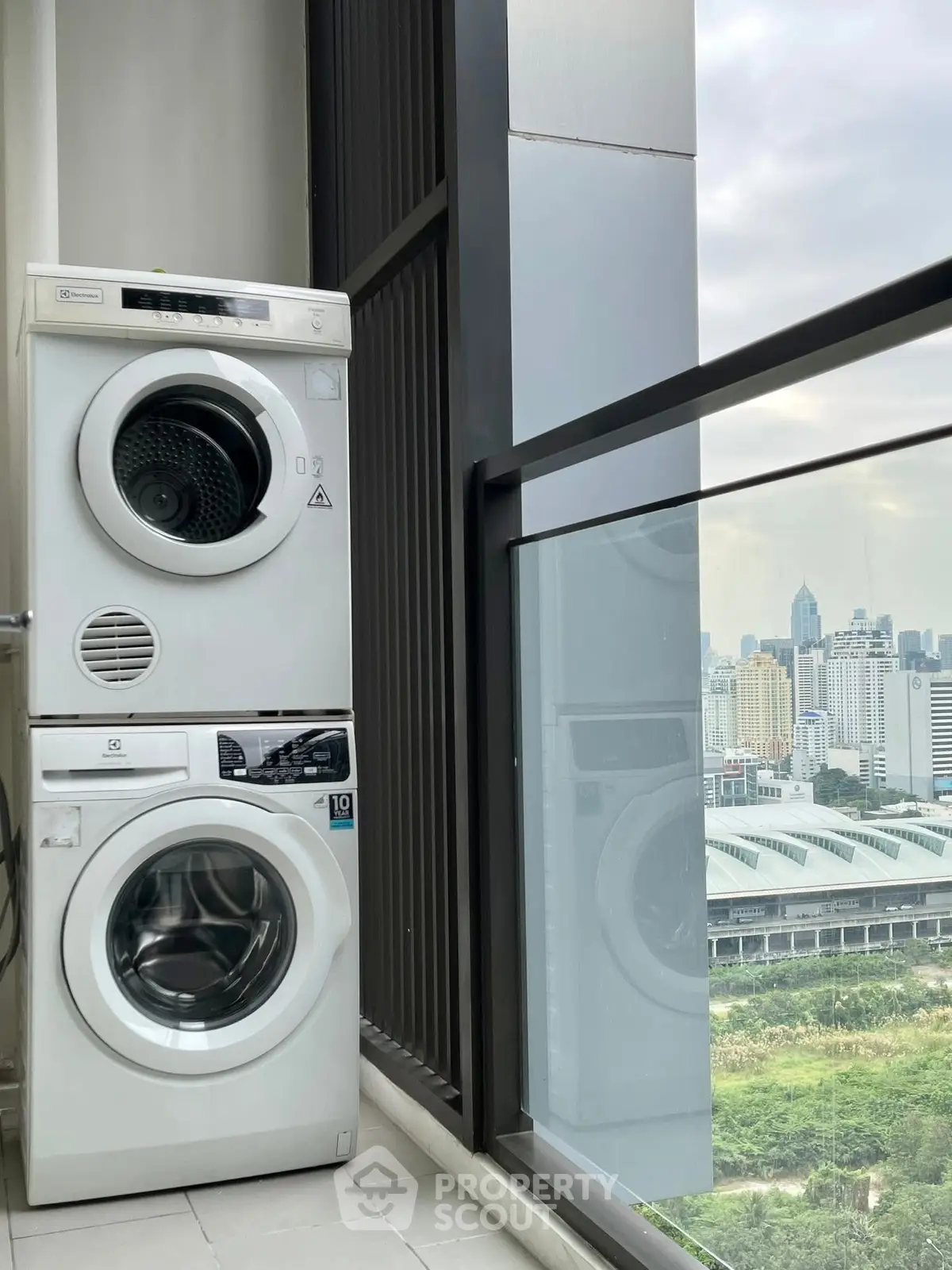 Modern laundry area with washer and dryer overlooking city skyline view.