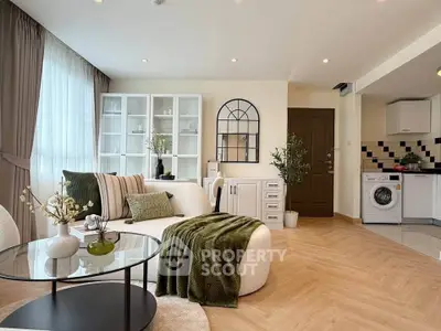 Modern living room with stylish decor and open kitchen featuring washing machine.