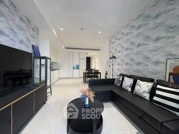 Modern living room with stylish decor and open layout, featuring a sleek black sofa and contemporary furnishings.