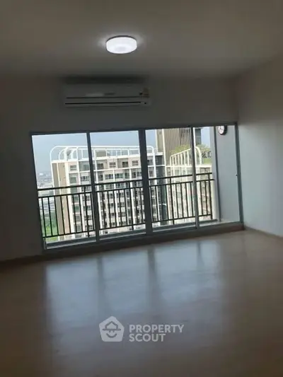 Spacious apartment with large windows and balcony offering city views.