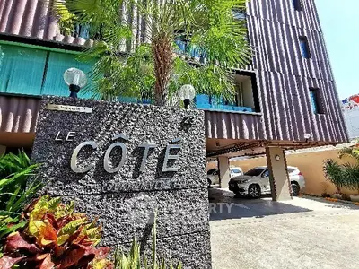 Modern apartment building with parking and lush greenery at Le Côté.