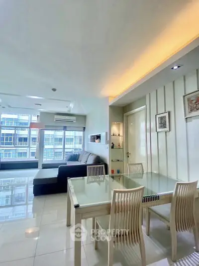 Modern living room with dining area, featuring sleek furniture and large windows for natural light.