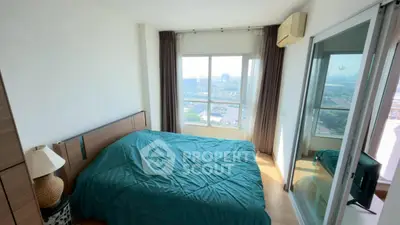 Bright bedroom with large window and city view, featuring modern decor and ample natural light.