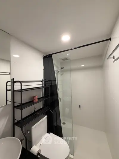 Modern bathroom with sleek shower and storage shelves in contemporary apartment.