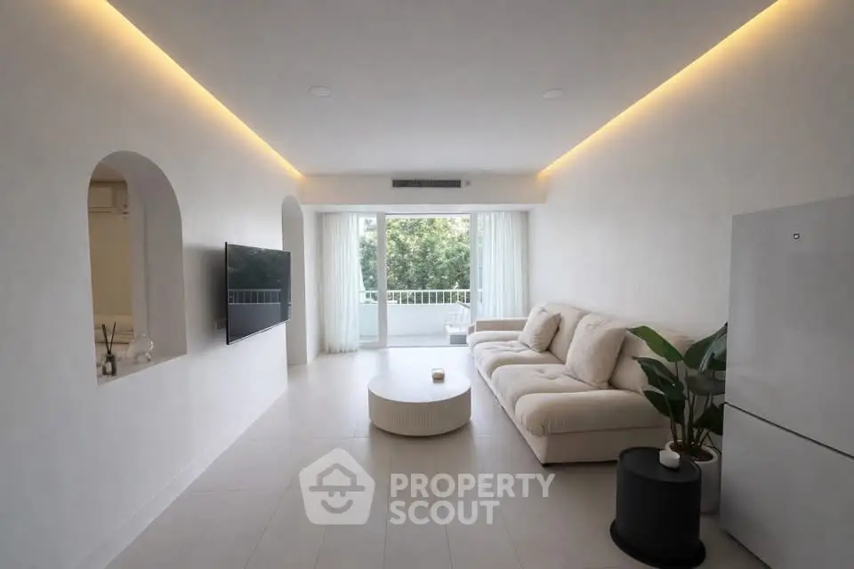 Modern living room with sleek design and large windows offering natural light.