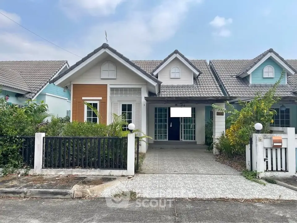 Charming single-story house with tiled driveway and lush greenery