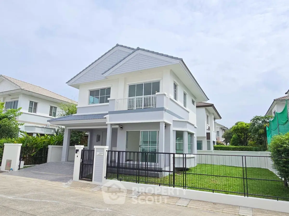 Charming two-story house with modern design and lush green lawn in a serene neighborhood.