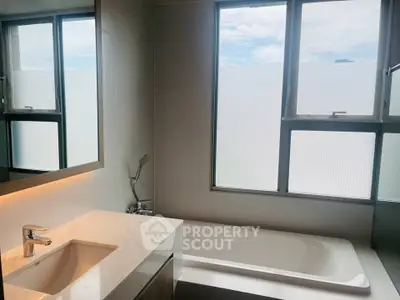 Modern bathroom with large window and sleek bathtub design