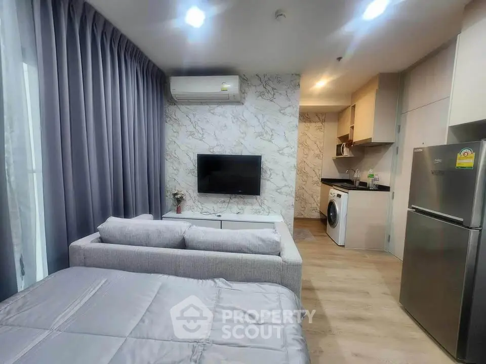 Modern studio apartment with stylish decor, featuring a cozy living area, sleek kitchen, and convenient in-unit laundry.