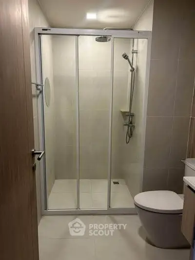 Modern bathroom with glass shower enclosure and sleek fixtures.