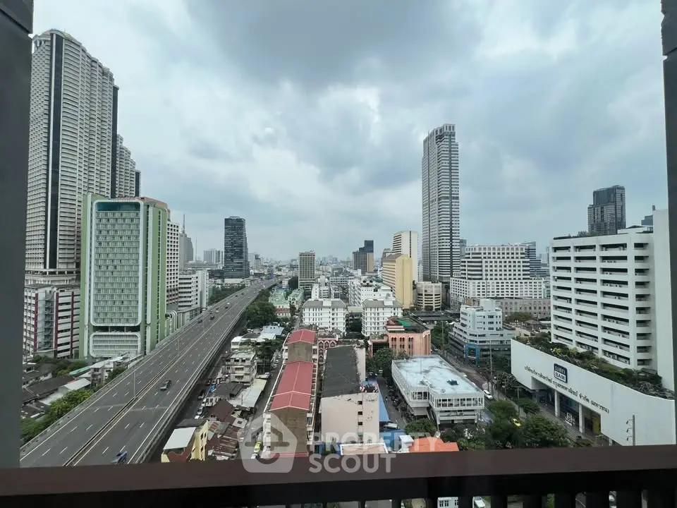 Stunning cityscape view from a high-rise balcony showcasing urban skyline and bustling streets.