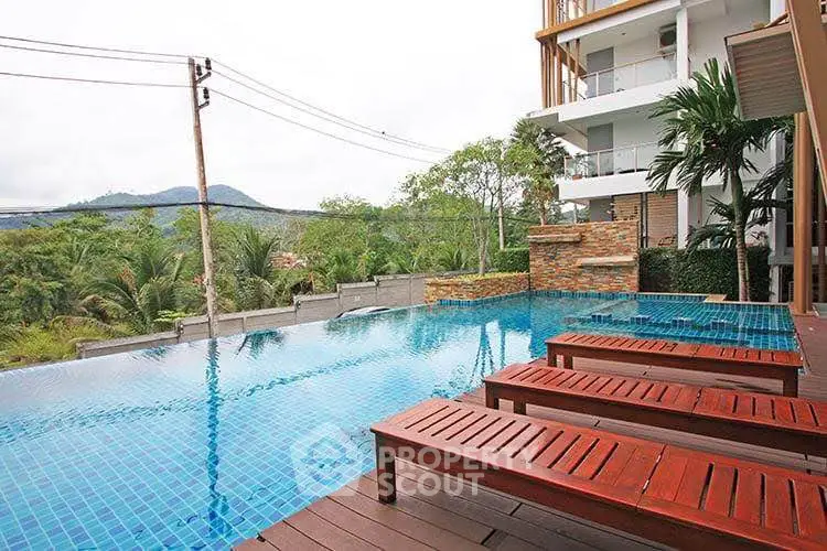 Luxurious poolside view with mountain backdrop in modern residential complex.
