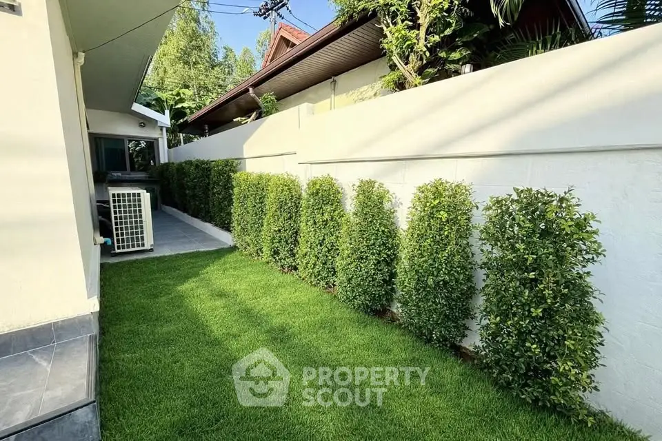 Charming garden area with lush greenery and modern exterior design, perfect for relaxation and outdoor activities.