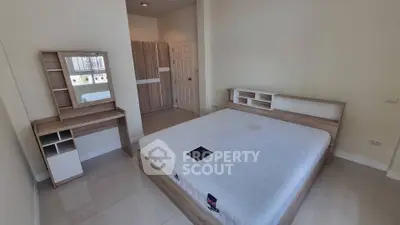 Spacious bedroom with modern wooden furniture and large bed in a bright apartment.