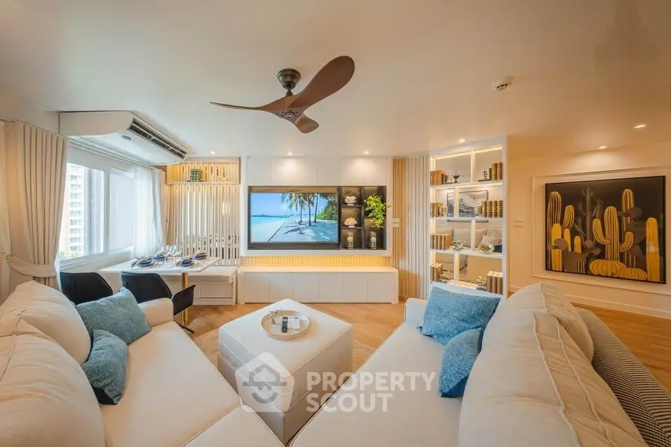 Luxurious living room with modern decor and large TV, perfect for relaxation and entertainment.