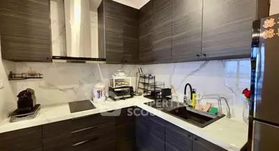 Modern kitchen with sleek dark cabinets and marble backsplash, featuring a built-in stove and stylish sink.