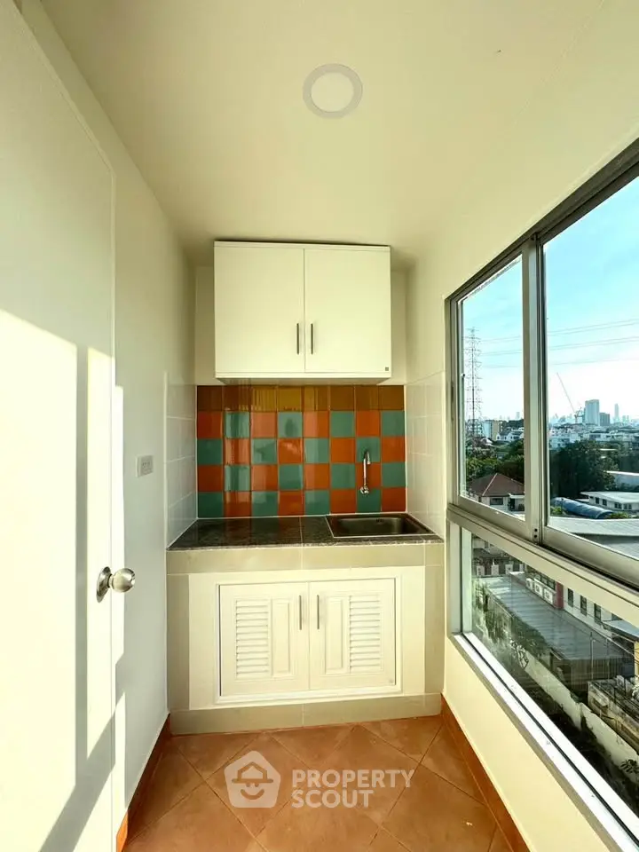 Compact kitchen with colorful backsplash and city view