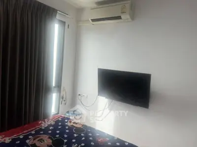Cozy bedroom with wall-mounted TV and air conditioning, featuring a large window for natural light.