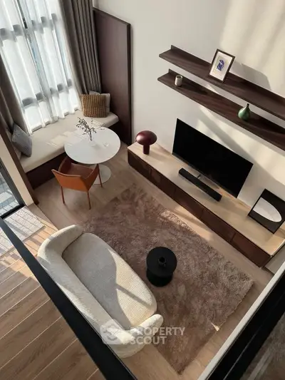 Modern living room with stylish furniture and natural light, featuring a cozy sofa and elegant decor.