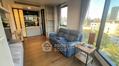 Modern living room with large windows and city view, featuring a comfortable leather sofa and stylish decor.
