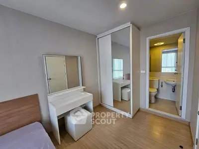 Modern bedroom with ensuite bathroom and mirrored wardrobe in stylish apartment.