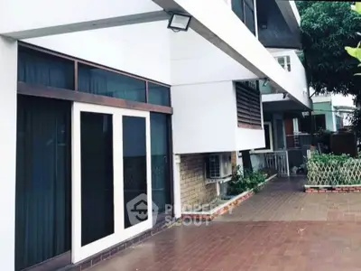 Modern building exterior with spacious patio and large windows, ideal for urban living.
