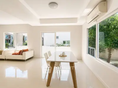 Bright and spacious living room with modern furniture and large windows offering garden views.