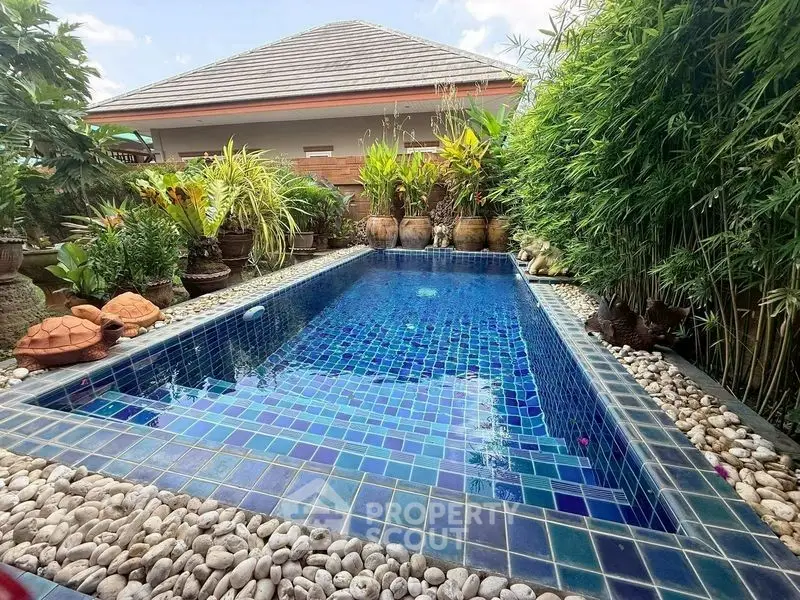 Stunning private pool surrounded by lush greenery and elegant stonework, perfect for relaxation and luxury living.