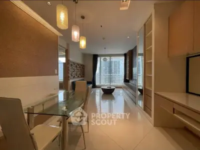 Spacious modern living room with elegant lighting and large windows offering city views.