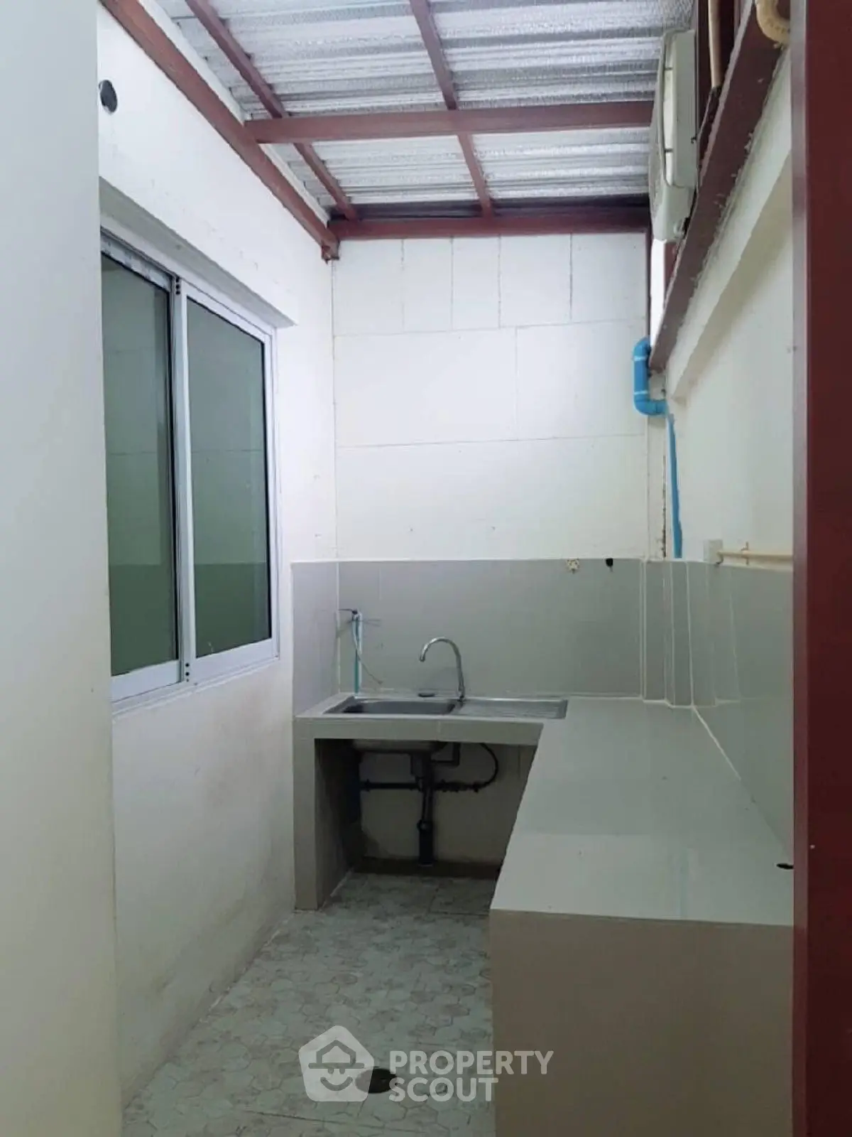 Compact kitchen area with sleek countertops and modern sink in a well-lit space.
