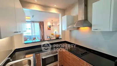 Modern kitchen with sleek design, featuring stainless steel appliances and open layout to dining area.