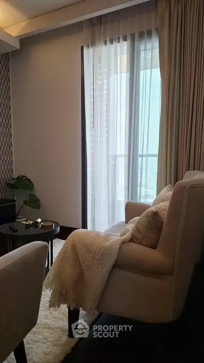Elegant living room with cozy seating and balcony view, perfect for relaxation and comfort.