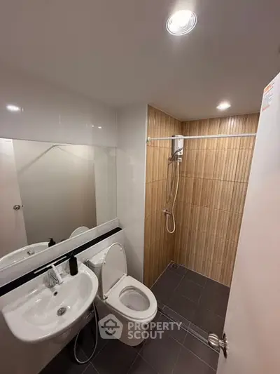 Modern bathroom with sleek fixtures and walk-in shower in a contemporary apartment.