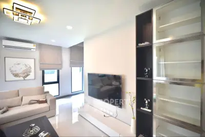 Modern living room with sleek design and large TV, perfect for relaxation.