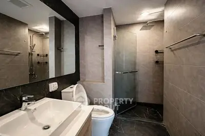 Modern bathroom with sleek design, featuring a glass shower and stylish fixtures.