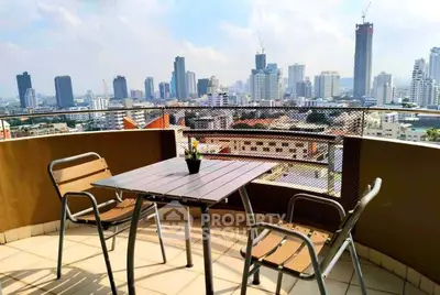 Stunning city view from a spacious balcony with modern outdoor seating, perfect for relaxation.