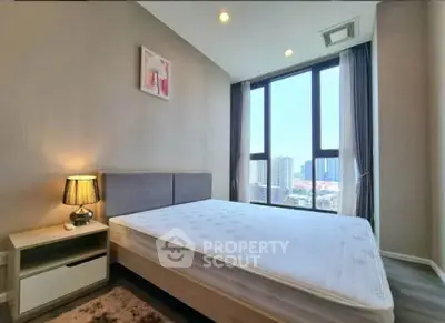 Modern bedroom with large windows offering stunning city views, featuring a cozy bed and elegant decor.