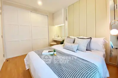 Modern bedroom with cozy bed, stylish decor, and ample closet space in a bright apartment.