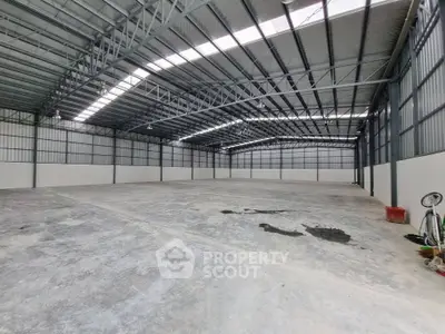 Spacious industrial warehouse with high ceilings and ample natural light.