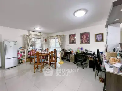 Spacious open-plan living area with dining and workspace, featuring modern decor and ample natural light.