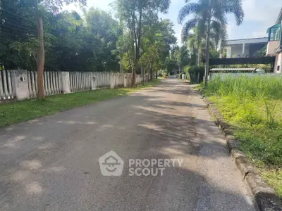 Charming suburban street view with lush greenery and modern homes, perfect for peaceful living.