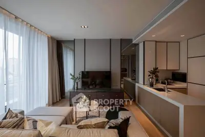 Modern living room with open kitchen, stylish decor, and large windows offering city views.