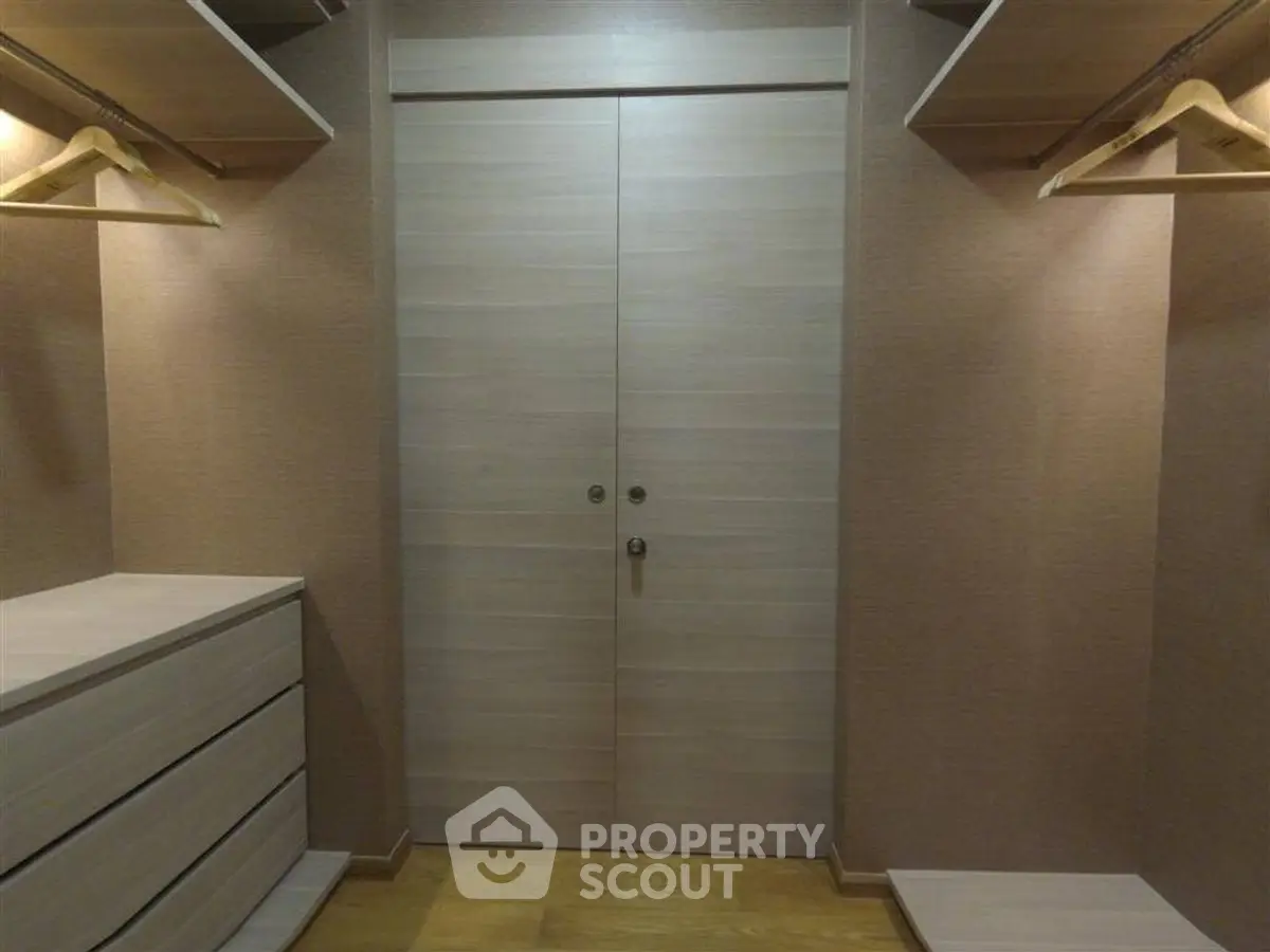Spacious walk-in closet with wooden shelves and drawers