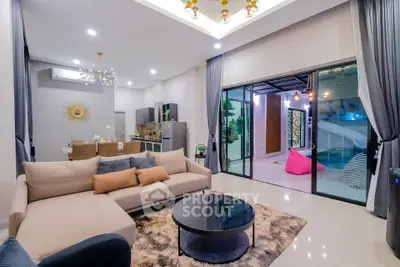 Luxurious open-plan living room with modern kitchen and pool view