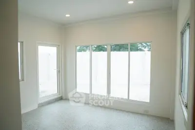 Bright and spacious room with large windows and modern lighting, perfect for a cozy living area.