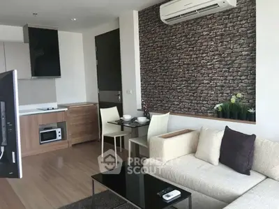 Modern living room with stylish brick accent wall and compact kitchen area
