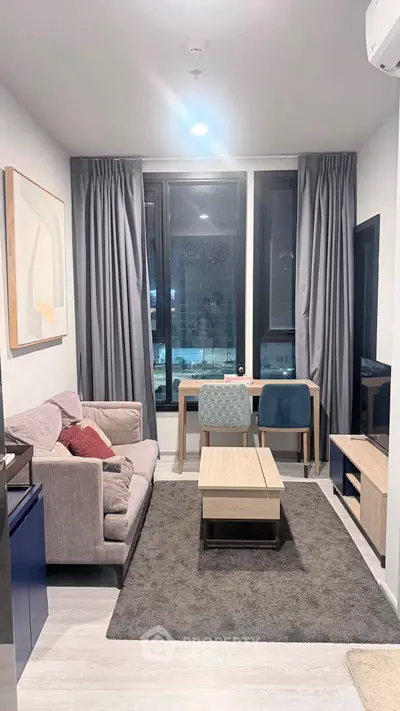 Modern living room with stylish furniture and large windows in a cozy apartment.