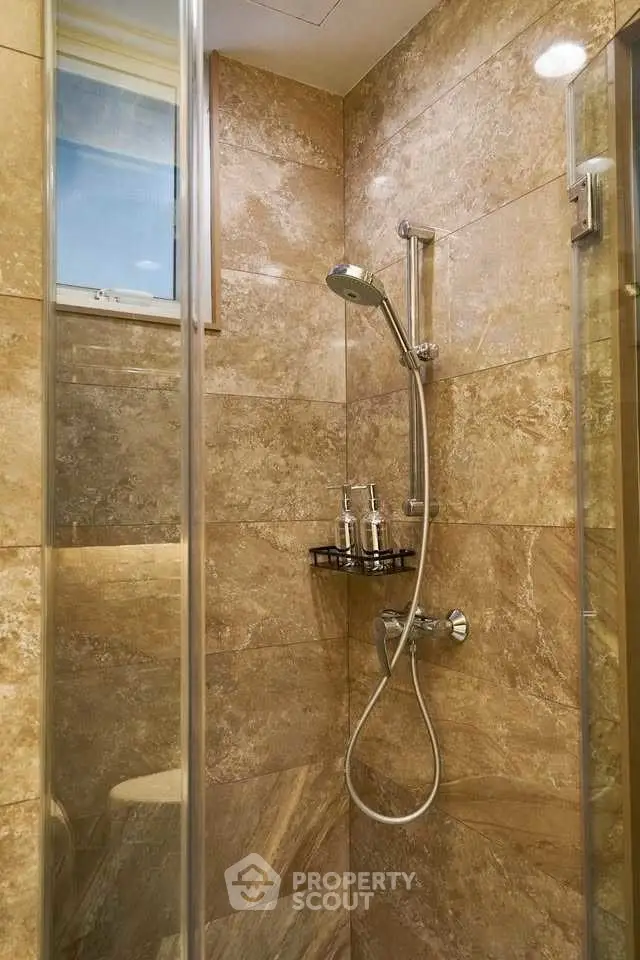 Luxurious marble-tiled bathroom shower with modern fixtures