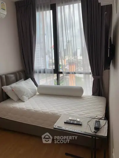 Cozy bedroom with city view, featuring a comfortable bed and modern decor.